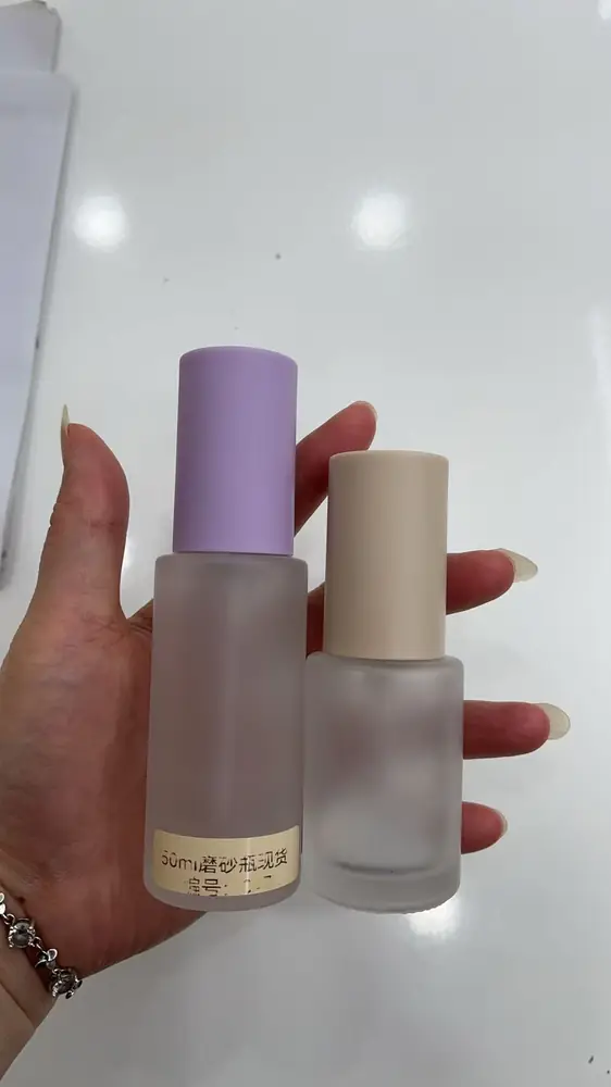 Hai chai chiết mỹ phẩm mini cầm trên tay